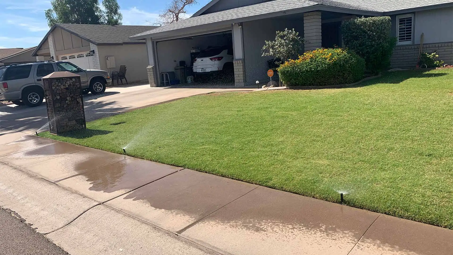 Irrigation sprinklers watering a lawn in Chandler, AZ.